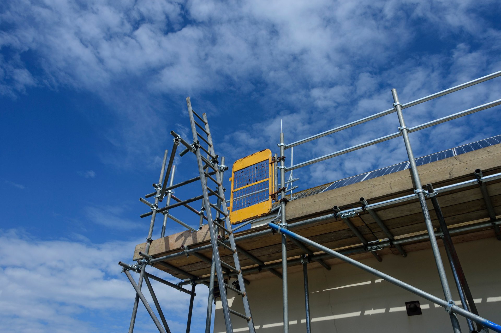 scaffolding on the side of a building with blue sky